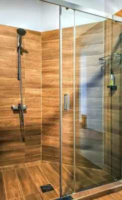 a shower with a glass door in a bathroom at Chic New Apt with Acropolis View in Monastiraki in Athens