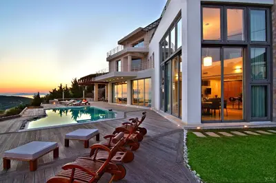 a house with a swimming pool and some chairs at Villa TakeOff Saronida in Anavissos