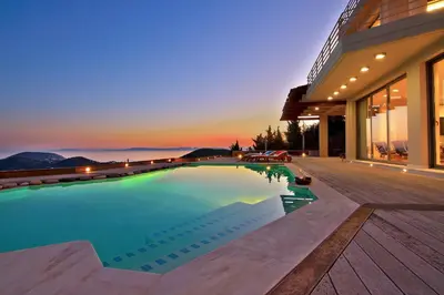 a swimming pool in front of a house at Villa TakeOff Saronida in Anavissos
