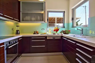 a kitchen with brown cabinets and a sink at Villa TakeOff Saronida in Anavissos
