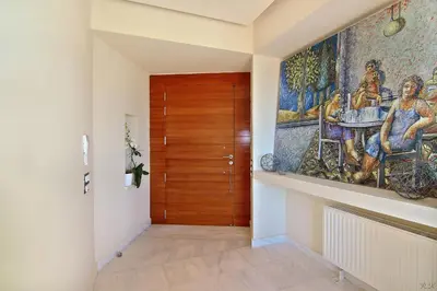 a hallway with a door and a painting on the wall at Villa TakeOff Saronida in Anavissos