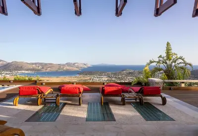 a patio with chairs and a view of the ocean at Villa TakeOff Saronida in Anavissos