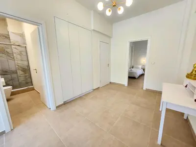 a large room with white cabinets and a bedroom at Prestige in Athens