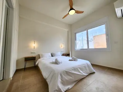 a bedroom with a white bed with a ceiling fan at Prestige in Athens