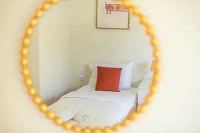 a mirror reflection of a bed with a red pillow at Lycabettus View Top Floor 2BdApt in Athens