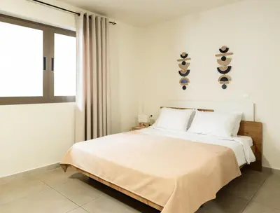 a bedroom with a bed with white sheets and a window at Elysee apartment 2 in Athens