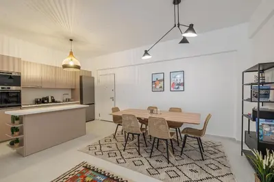 a kitchen and dining room with a wooden table and chairs at Cozy 3 bdr Apartment next to Acropolis in Athens