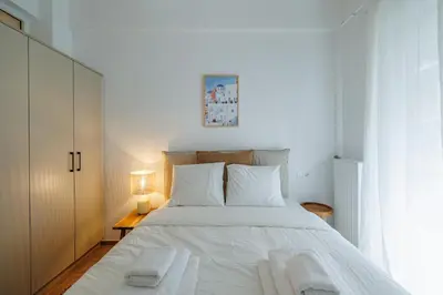 a bedroom with a large white bed with two towels at Cozy 3 bdr Apartment next to Acropolis in Athens