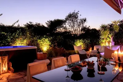 a patio with a table and chairs and a fireplace at Cyan Villa in Anavissos
