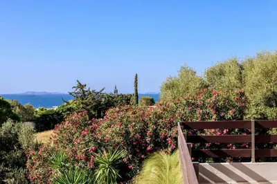 a wooden bench in front of some pink flowers at Cyan Villa in Anavissos