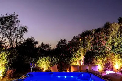 a garden with chairs and lights at night at Cyan Villa in Anavissos