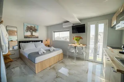 a bedroom with a large bed and a kitchen at Paradise Heated Jacuzzi with Acropolis View in Athens