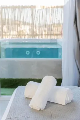 a pair of towels on a bed next to a swimming pool at Paradise Heated Jacuzzi with Acropolis View in Athens