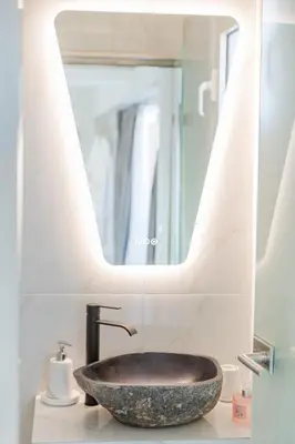 a bathroom with a sink and a mirror at Paradise Heated Jacuzzi with Acropolis View in Athens