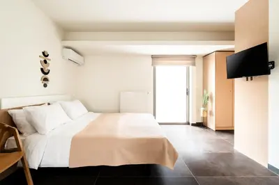 a bedroom with a bed with white sheets and a window at Elysee apartment 9B in Athens