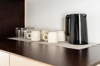 a black coffee pot sitting on a shelf with mugs at Elysee apartment 9B in Athens