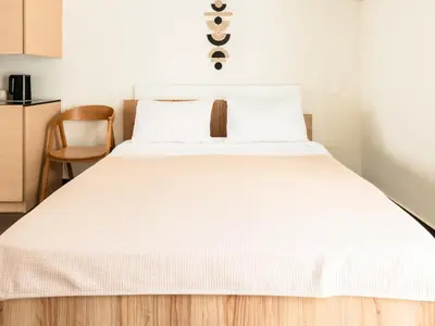 a bedroom with a white bed and a chair at Elysee apartment 9B in Athens