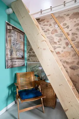 a wooden staircase in a room with a chair at Athenian Cypress House in Athens