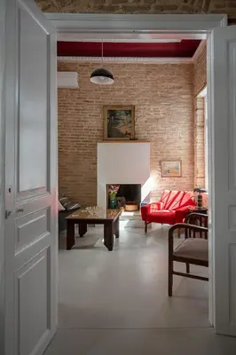 a living room with a red couch and a fireplace at Athenian Cypress House in Athens