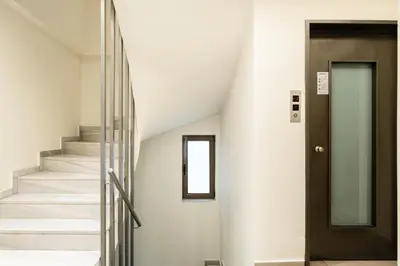 a stairway with a black door and white stairs at Elysee apartment 5 in Athens