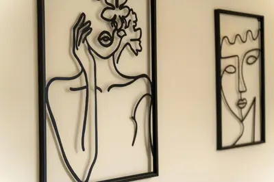 two framed drawings of a woman on a wall at Elysee apartment 5 in Athens