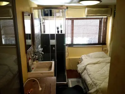 a small bathroom with a bed and a sink at OneStep mini apartment next to Kallimarmaro Stadium in Athens