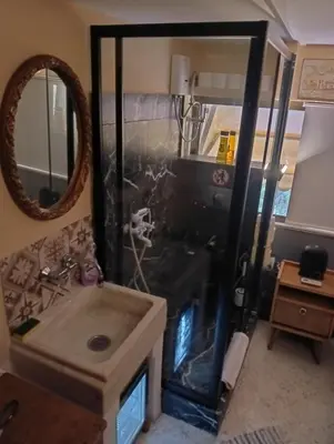 a shower with a sink and a mirror in a room at OneStep mini apartment next to Kallimarmaro Stadium in Athens