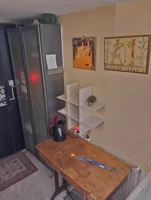 a room with a wooden table and a refrigerator at OneStep mini apartment next to Kallimarmaro Stadium in Athens