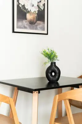 a black dining table with a black vase on it at Elysee apartment 7 in Athens
