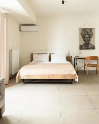 a bedroom with a bed and a table at Elysee apartment 8 in Athens