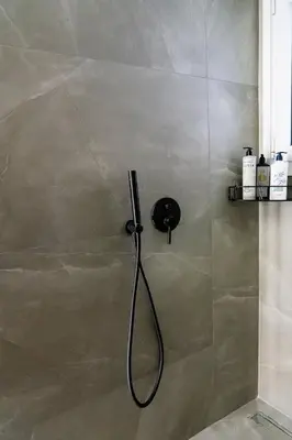 a shower with a black shower head in a bathroom at Central Athens Spacious Boho Retreat In Acropolis in Athens