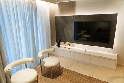 a living room with a tv and two chairs at Central Athens Spacious Boho Retreat In Acropolis in Athens