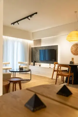 a living room with a flat screen tv and chairs at Central Athens Spacious Boho Retreat In Acropolis in Athens