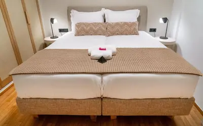 a bedroom with a large bed with two towels at Central Athens Spacious Boho Retreat In Acropolis in Athens