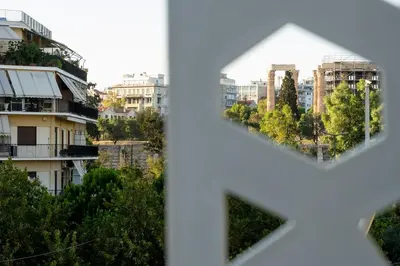 a view of a city through a heart shaped window at Central Athens Spacious Boho Retreat In Acropolis in Athens