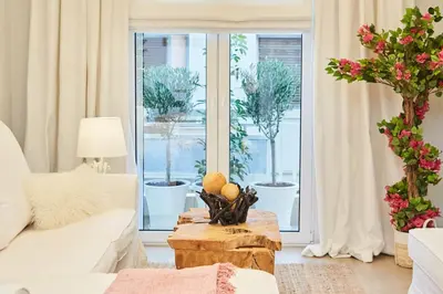 a living room with a white couch and a table at Calypso Apartment in Athens