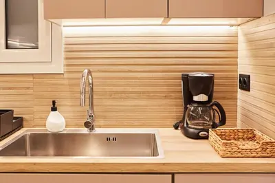 a kitchen with a sink and a coffee maker on a counter at Calypso Apartment in Athens