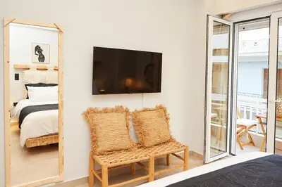 a bedroom with a bed and a tv and a mirror at Calypso Apartment in Athens