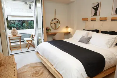 a bedroom with a large bed and a balcony at Calypso Apartment in Athens