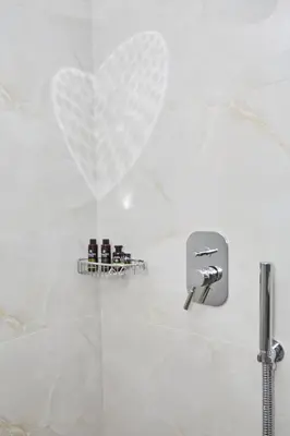 a white bathroom with a heart on the wall at Calypso Apartment in Athens