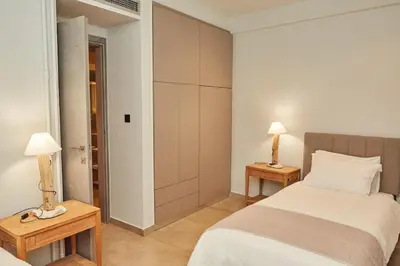 a bedroom with a bed and two lamps on tables at Calypso Apartment in Athens
