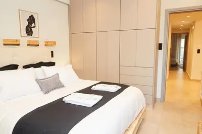 a bedroom with a large white bed with towels on it at Calypso Apartment in Athens