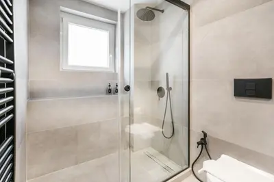 a bathroom with a shower with a toilet and a window at Astoria - Luxury 2-BR Apartment in Athens in Athens