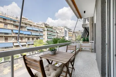 a balcony with a wooden table and two chairs at Astoria - Luxury 2-BR Apartment in Athens in Athens
