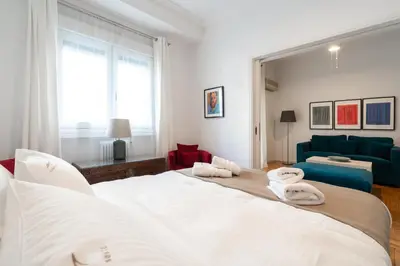 a bedroom with two beds and a blue couch at Artistic Elegance in central Athens, Pangrati in Athens