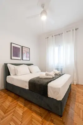 a bedroom with a large bed with white walls at Artistic Elegance in central Athens, Pangrati in Athens