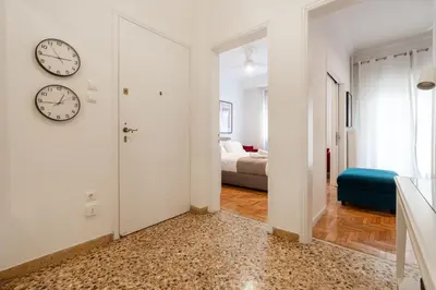 a hallway with a clock on the wall and a bedroom at Artistic Elegance in central Athens, Pangrati in Athens