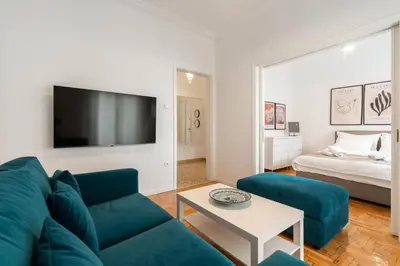 a living room with a blue couch and a tv at Artistic Elegance in central Athens, Pangrati in Athens