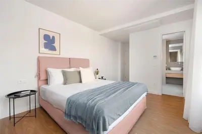 a bedroom with a large bed and a bathroom at Monastiraki Living Flats by UPSTREET in Athens
