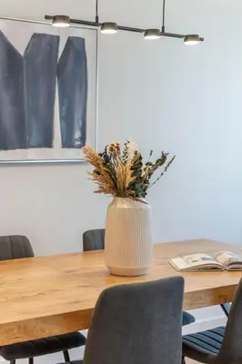 a vase with flowers sitting on a wooden table at Monastiraki Living Flats by UPSTREET in Athens